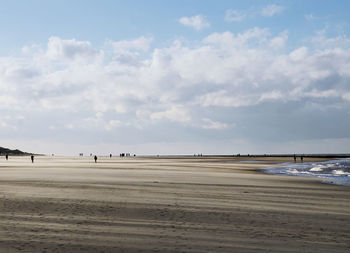 Scenic view of beach against cloudy sky