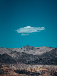 Scenic view of mountains against blue sky