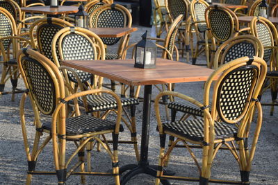 Empty chairs and tables at sidewalk cafe