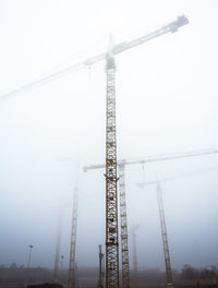 Low angle view of crane against sky