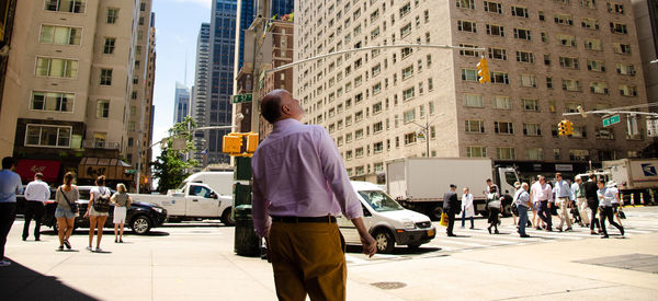 Rear view of people walking on street in city