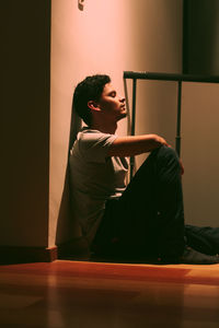 Young man looking away while sitting 