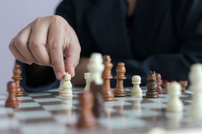 Midsection of man playing with chess