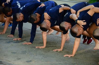 People exercising while bending on road