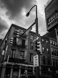 Low angle view of road sign against sky in city