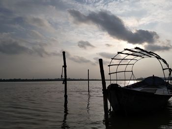 Fishing boat in sea against sky during sunset