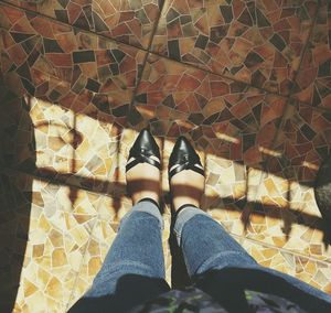 Low section of woman standing on tiled floor