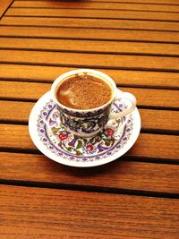 Directly above shot of coffee cup on wooden table