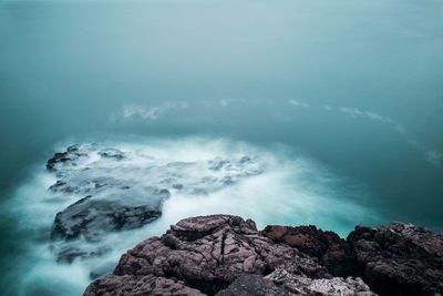 Scenic view of sea and rocks against sky