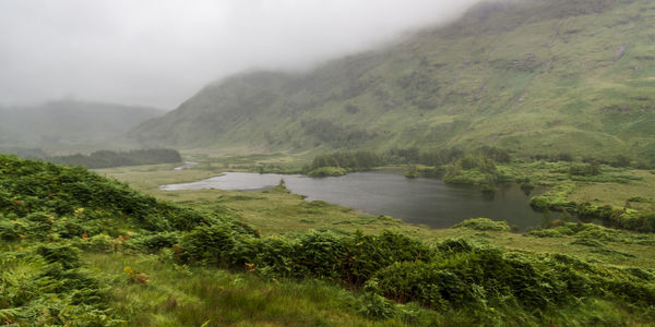 Scenic view of river by mountains