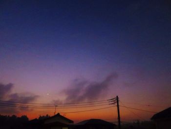 Low angle view of silhouette cables against sky during sunset