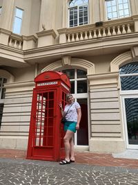 Full length of woman standing by building