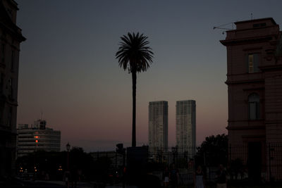 Silhouette buildings against sky at dusk