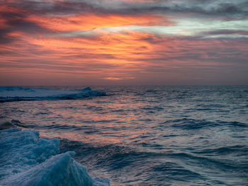 Winter landscape from the sea shore, blurred wave slags against frozen ice cubes