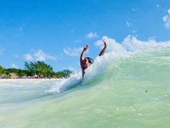 Man surfing in sea against sky