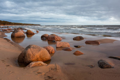 Rocks on beach against sky