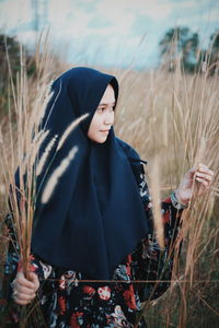 Young woman standing amidst plants