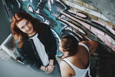 Portrait of beautiful woman against wall