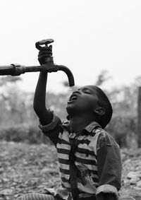 Boy drinking water from faucet