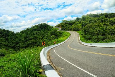 Road amidst trees against sky