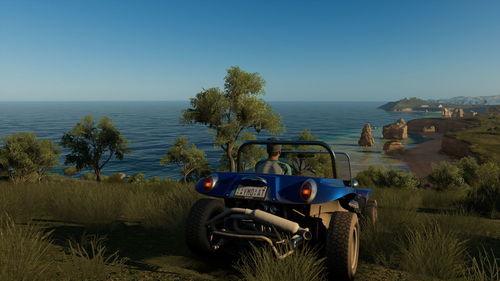 Tractor on beach against clear sky