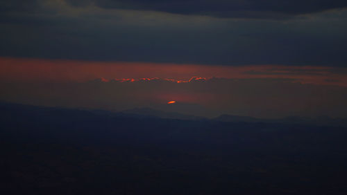 Scenic view of dramatic sky over silhouette landscape