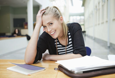 Close up portrait of smiling young woman with hand in hair