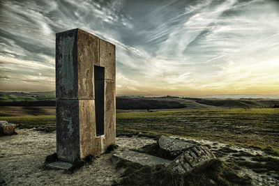 Old ruin on field against sky during sunset