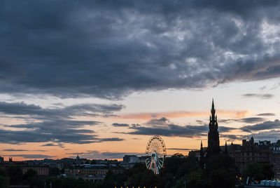 Buildings in city against cloudy sky