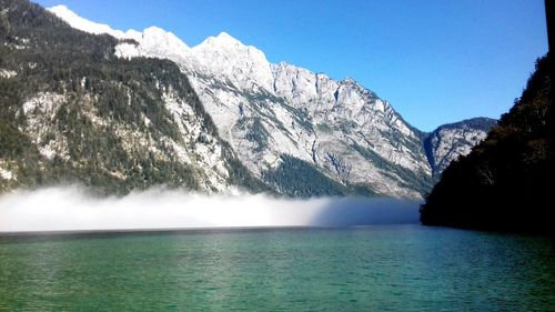 Scenic view of lake and snowcapped mountains against sky