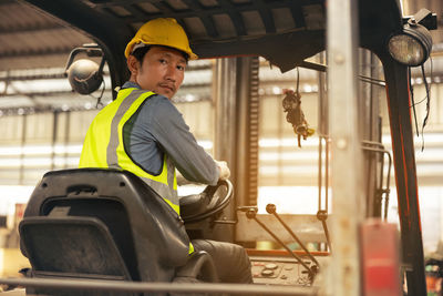 Engineer man forklift driver with a background in an industrial or warehousing factory.