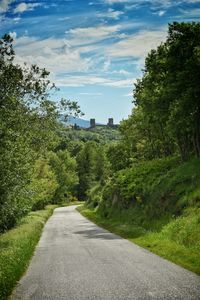 Road amidst trees against sky