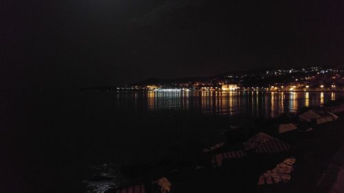 High angle view of illuminated city by water at night