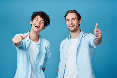 Portrait of smiling young man against blue background