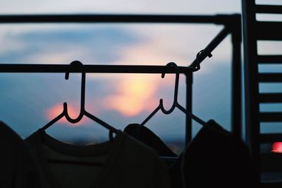 Close-up of silhouette railing against sky during sunset