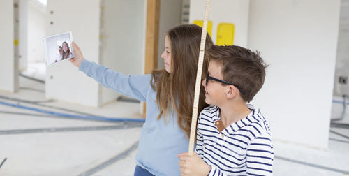 Cute sibling taking selfie at construction site