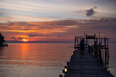 Pier over sea against sky during sunset
