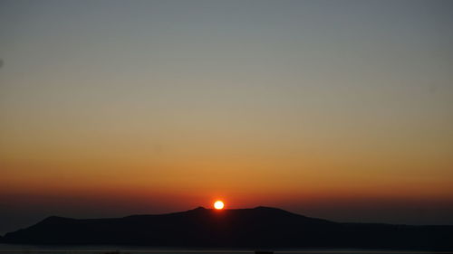 Scenic view of silhouette mountains against romantic sky at sunset