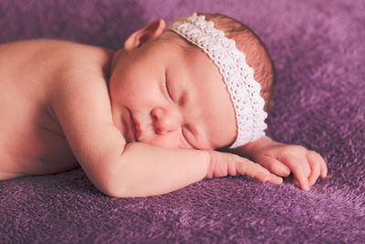 Close-up of baby sleeping on bed