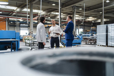 Male professionals having discussion at factory