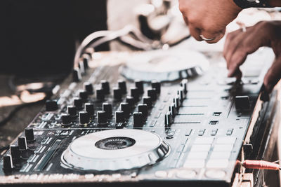 Cropped hands of musician adjusting sound mixer