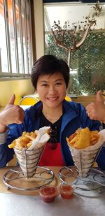Portrait of smiling boy holding ice cream on table