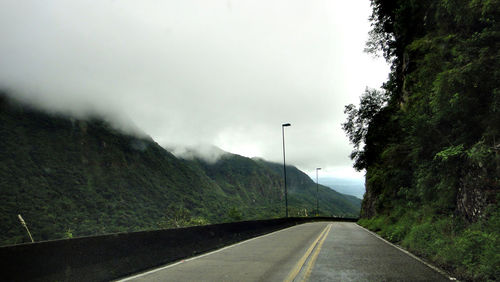 Road amidst trees against sky