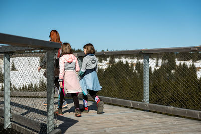 Children on woman against sky