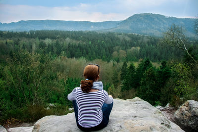 Rear view of woman sitting on mountain