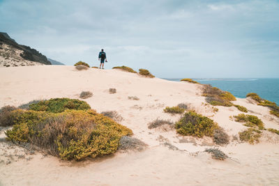 Traveler and photographer on dune landscape on the atlantic coastline. sao vicente, cape verde