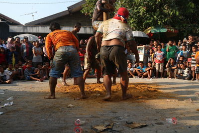 Rear view of people walking on street in city