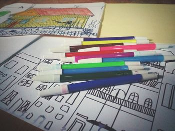 High angle view of multi colored pencils on paper