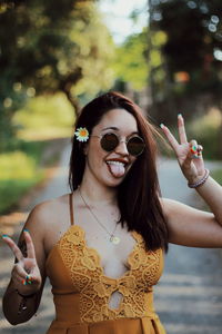 Portrait of a smiling young woman holding sunglasses