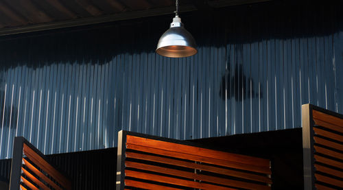 Low angle view of illuminated lights hanging on ceiling of building